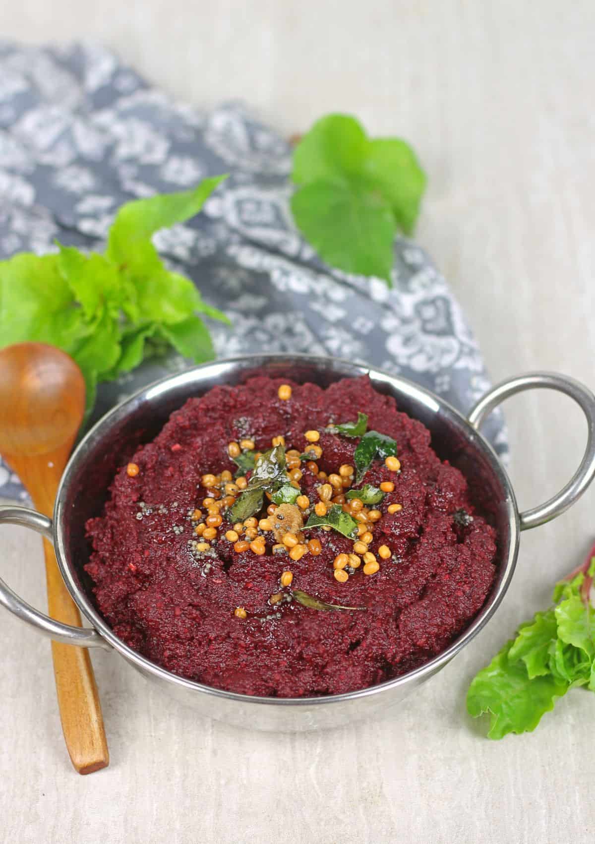 beetroot chutney with seasoning on top and beet greens on the side