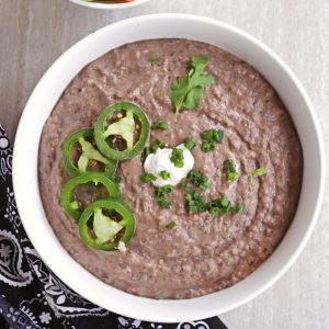 black bean dip with jalapeno and sour cream garnish