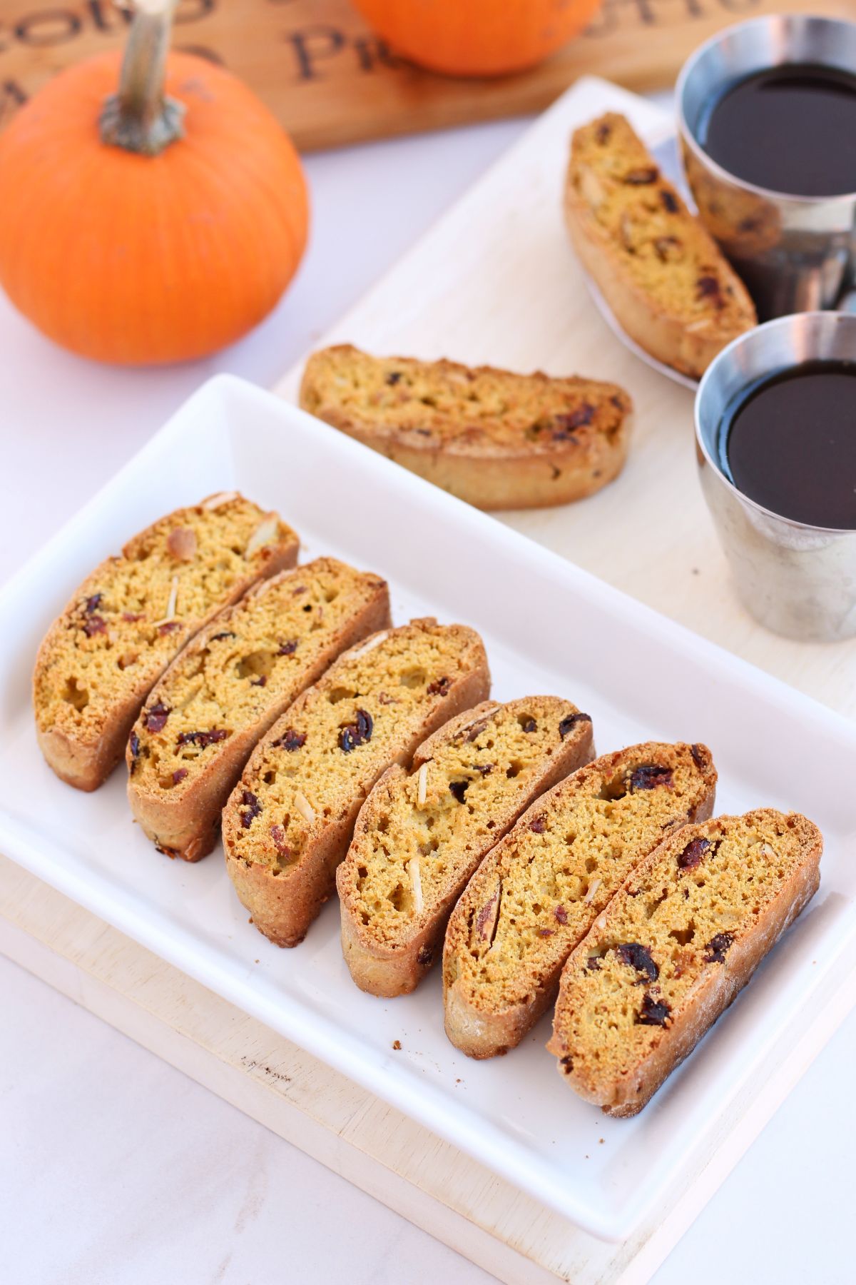 pumpkin biscotti on a plate with pumpkin in the background