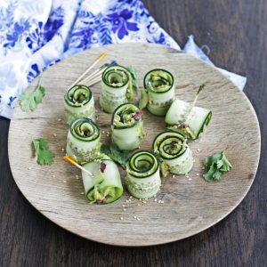 cucumber rolls layered with smashed avocado in a plate