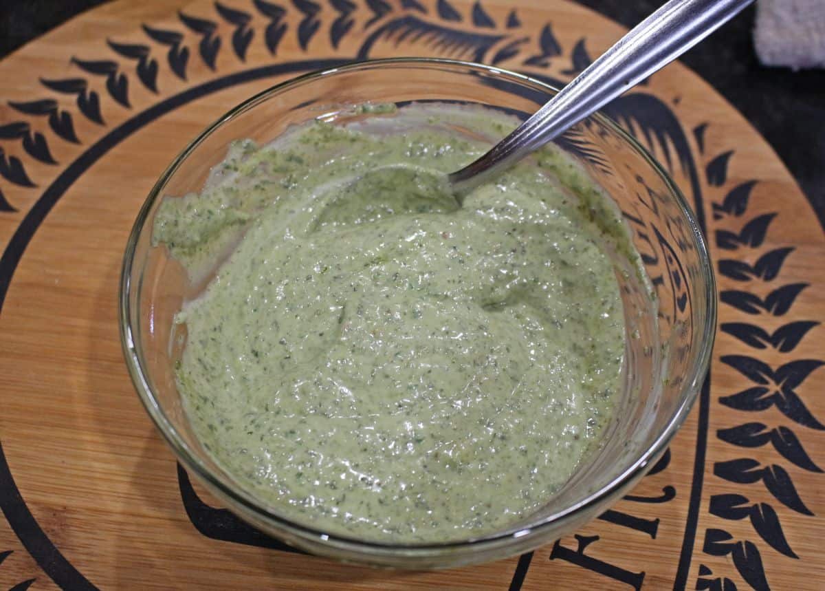 Pesto mayo combined in a bowl with a spoon.