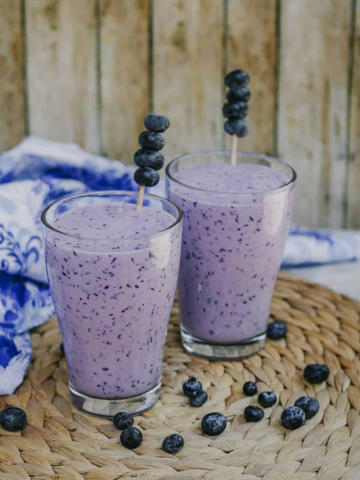 Blueberry lassi in two glasses with blueberry garnish