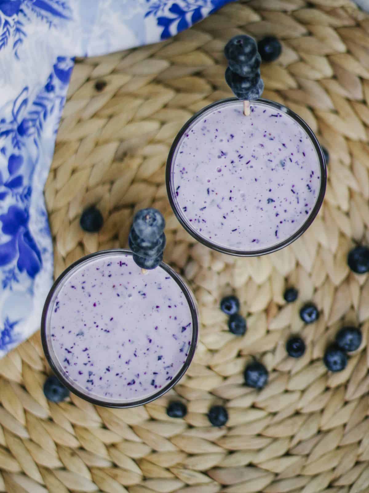Top view of Blueberry lassi in two glasses with blueberry garnish