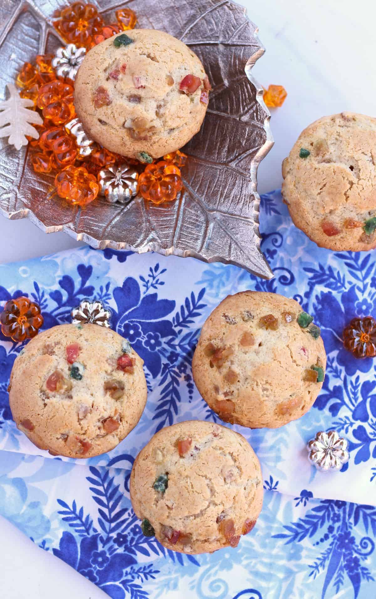 Top view of muffins on a silver plate and blue cloth. 