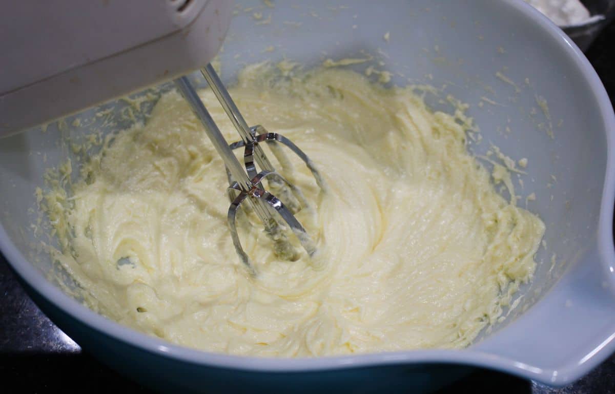 Creaming butter and sugar with a hand mixer.