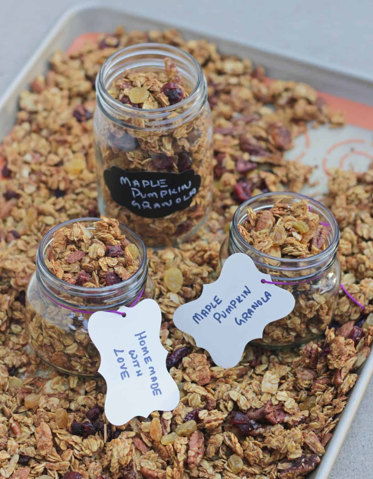 Granola packed for gifts in jars and more granola on tray.
